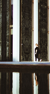 Person walking past architectural stone columns