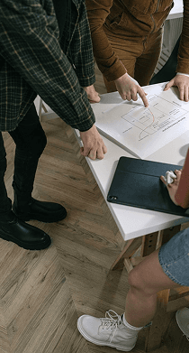 Collaborative team gathered around a strategic blueprint table